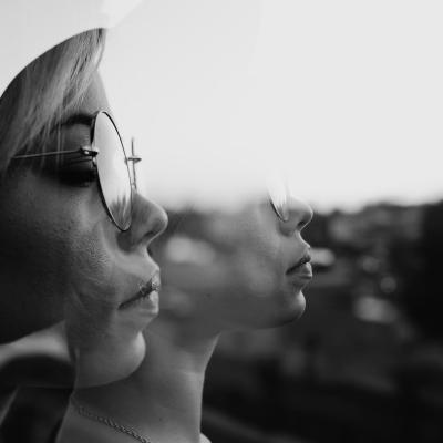 Twee vrouwen met zonnebrillen delen een betekenisvolle blik, die kameraadschap vertegenwoordigt in momenten van verdriet en herinnering.